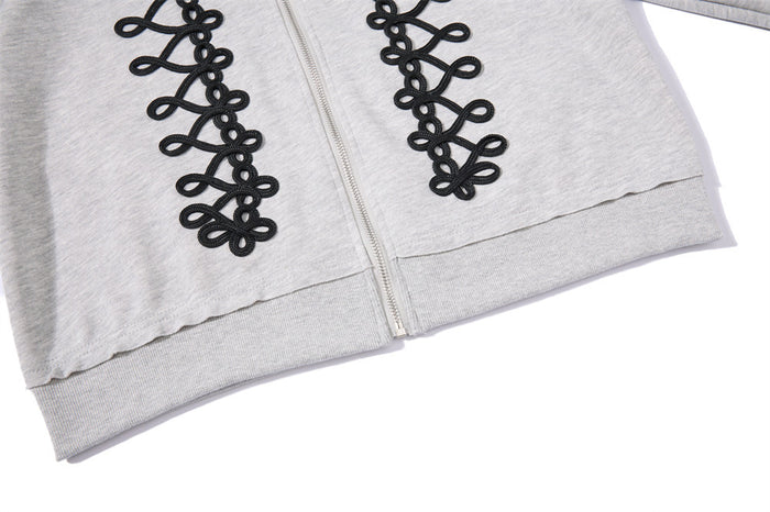 Close-up of the light gray hoodie ribbed hem and front zipper with black rope-lace panels