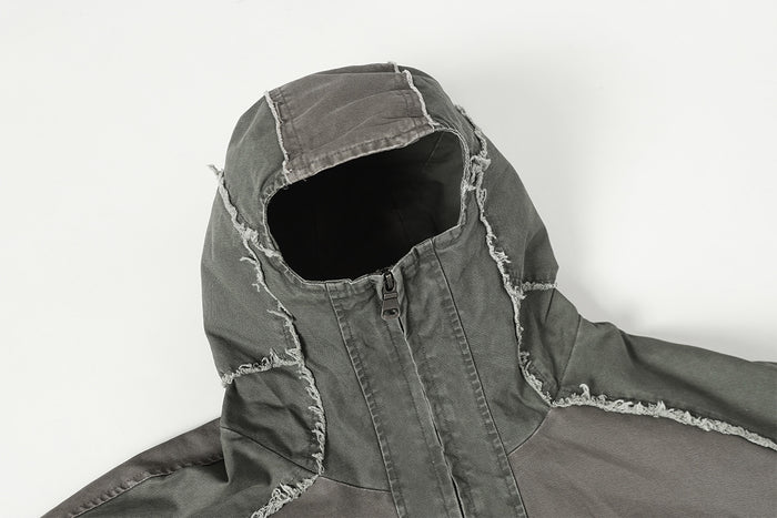 Close-up of the charcoal gray jacket hood, raised collar, zipper, and frayed panel edges