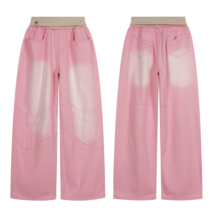 Front view of pink washed wide-leg jeans with contrast faded panels, curved seam detailing, and ribbed beige elastic waistban