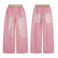 Front view of pink washed wide-leg jeans with contrast faded panels, curved seam detailing, and ribbed beige elastic waistban