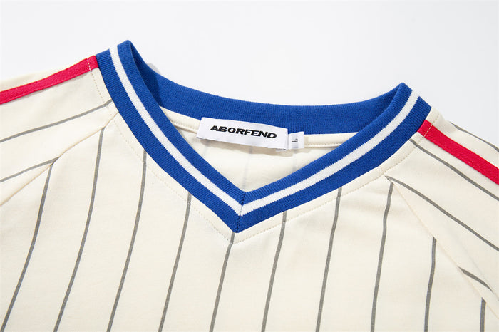 Close-up of cream pinstripe jersey V-neck with blue and white striped collar