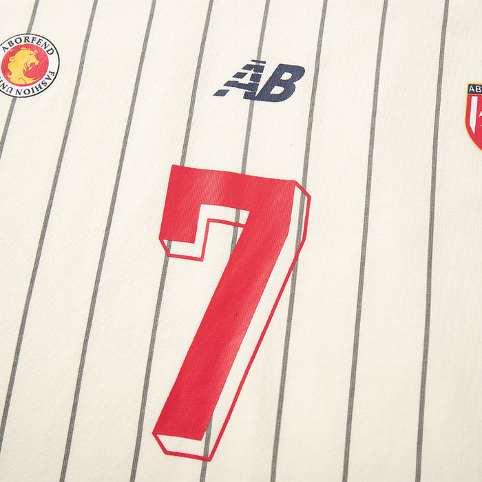 Close-up of front chest graphics on cream pinstripe soccer jersey with number 7 and small logos