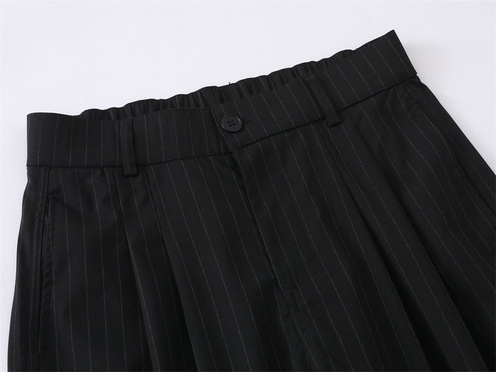 Close-up of black pinstripe waistband with belt loops and a button closure