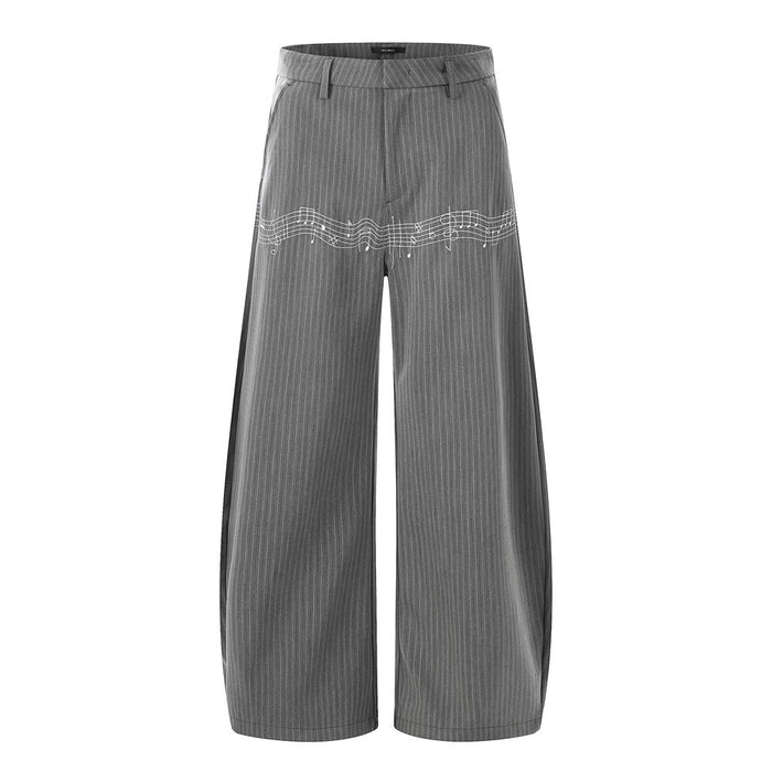 Front view of gray pinstripe wide-leg trousers with white music note embroidery across the thighs