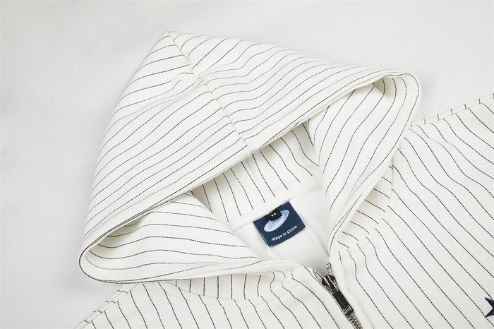 Close-up of the white pinstriped hoodie hood, inner label, seam, and partially visible front zipper