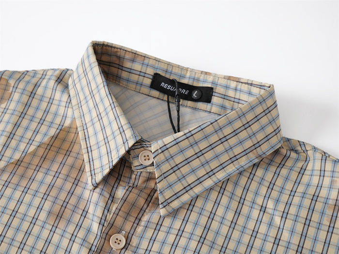 Close-up of plaid collar and top button on beige-blue short-sleeve shirt