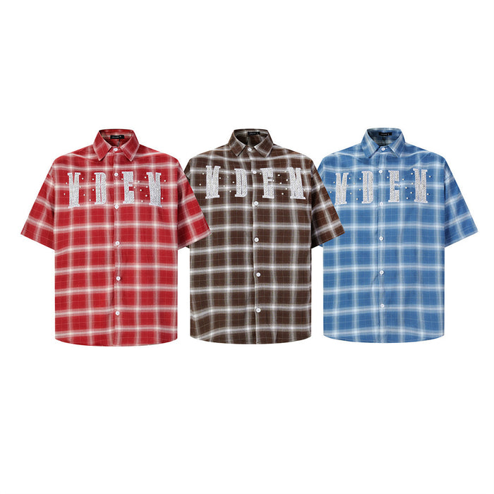 Three plaid short-sleeve button-up shirts in red, brown, and blue with embroidered letter patches and pearl studs