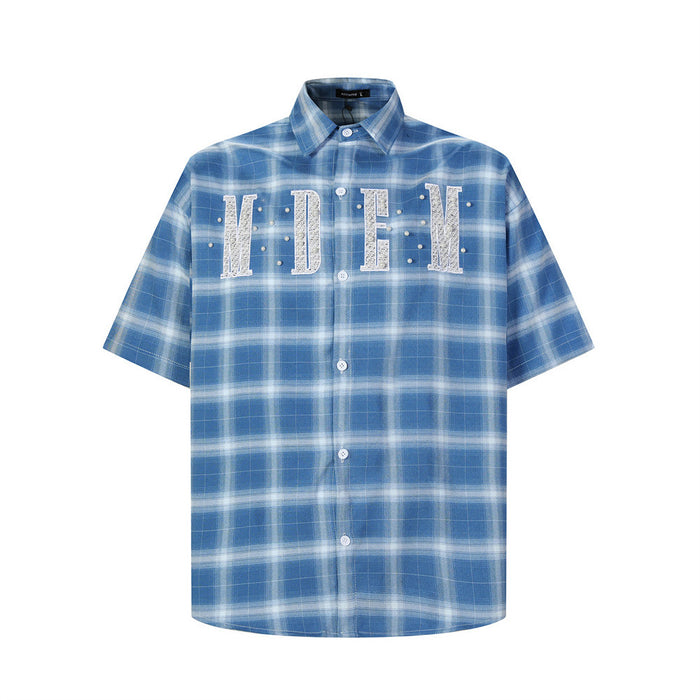 Blue plaid short-sleeve button-up shirt with embroidered letter patch and pearl studs, front view