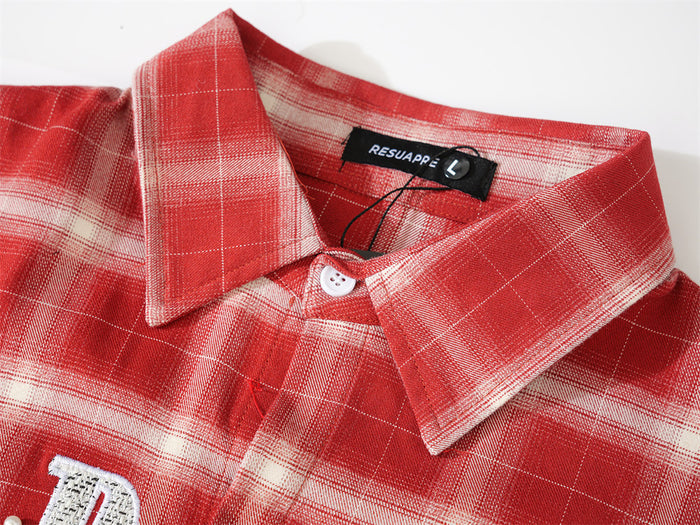 Close-up of red plaid shirt collar and top button with brand label inside