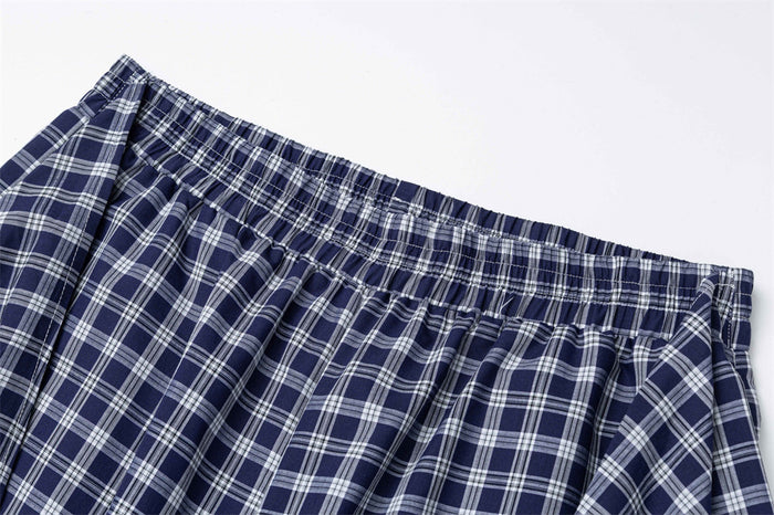 Close-up of gathered elastic waistband on navy plaid pants