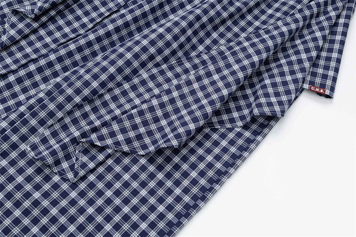 Close-up of layered plaid fabric panels on the pants front