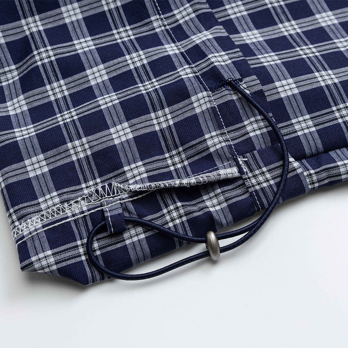 Close-up of hem drawstring and stitching on navy plaid pants