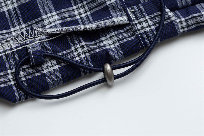 Close-up of adjustable hem drawstring with metal toggle on plaid pants