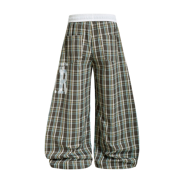 Back view of plaid wide-leg parachute pants with oversized legs and printed left side detail