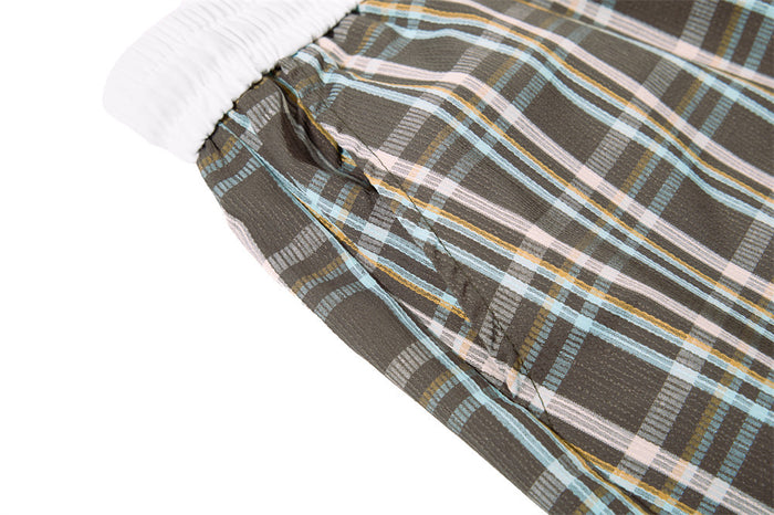 Close-up of plaid fabric seam near the waistband on the pants leg