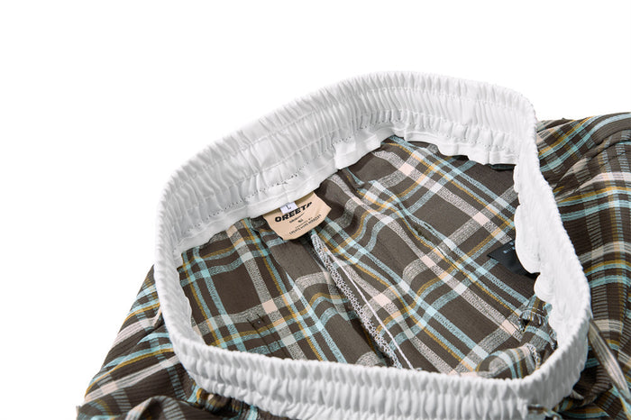 Close-up of white elastic waistband and interior label on plaid pants