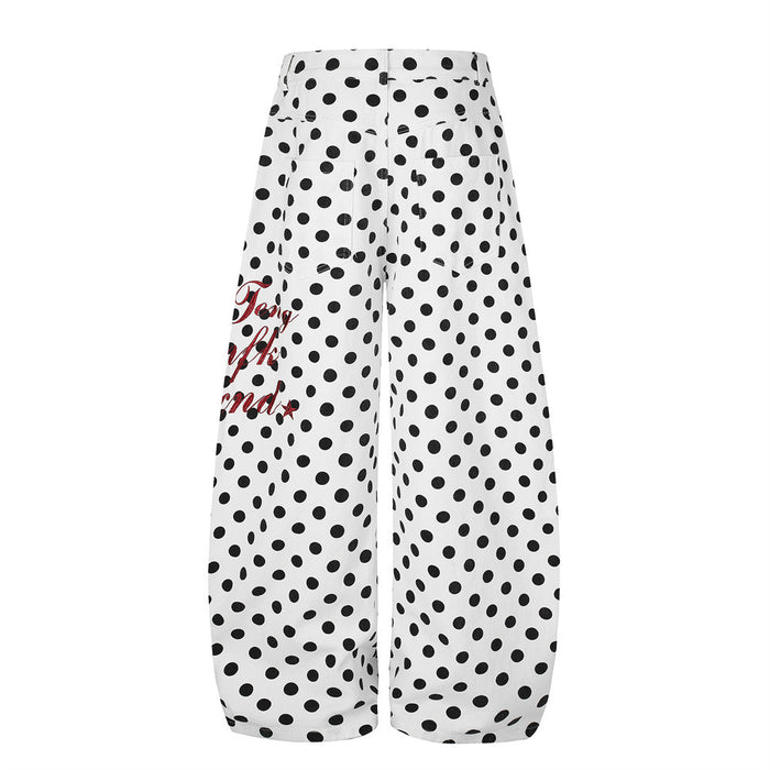 Rear view of white wide-leg polka dot pants showing the curved hems and partial red side graphic