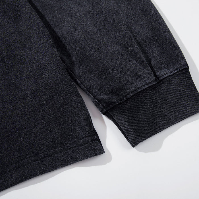 Close-up of the cuff and hem on a washed black long sleeve T-shirt