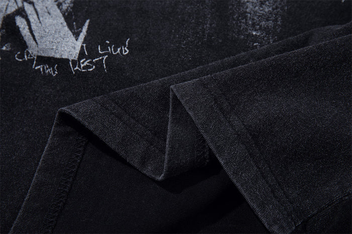 Close-up of the sleeve and printed graphic on a washed black long sleeve T-shirt