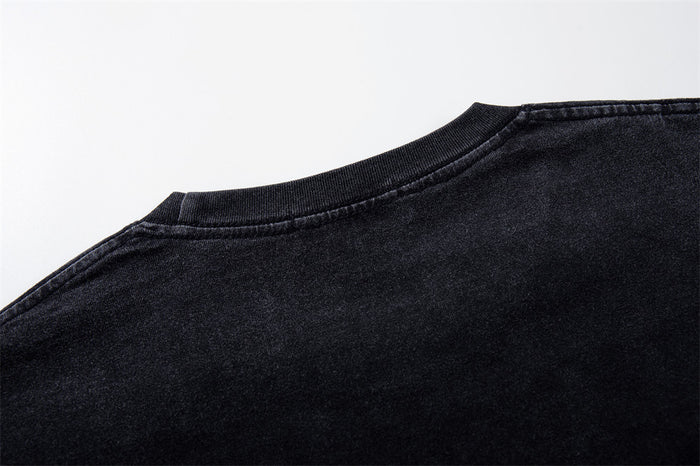 Close-up of the back neckline and shoulder seam on a washed black T-shirt