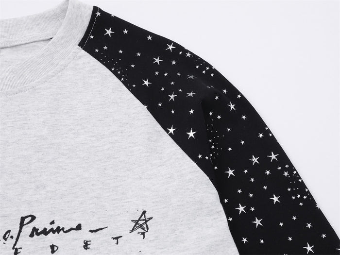 Close-up of the black star-print sleeve beside the light gray front graphic on the tee