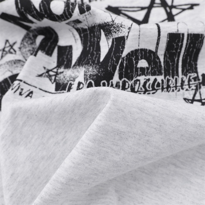 Close-up of the tee's distressed black graphic print and light gray knit fabric texture