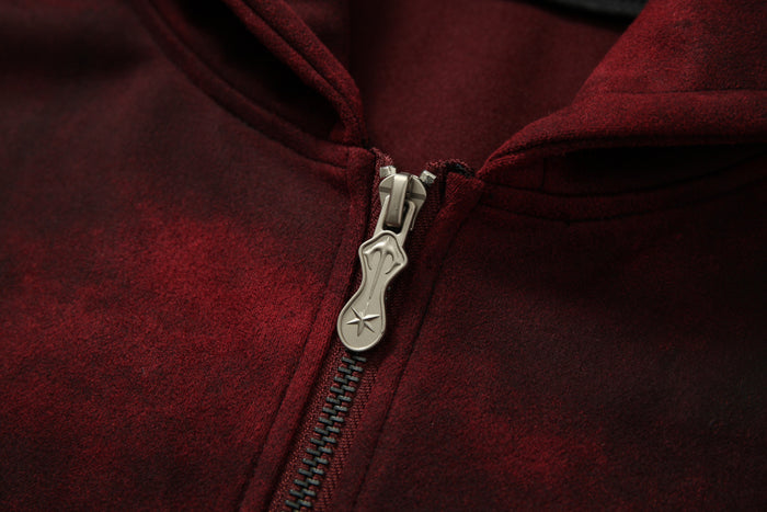 Close-up of silver zipper pull on burgundy hoodie