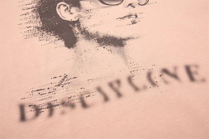 Close-up of DISCIPLINE text below portrait graphic on beige tank top