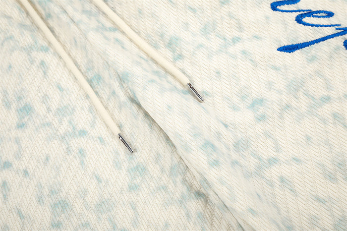 Close-up of the embroidered seam and drawstring on acid wash sweatpants