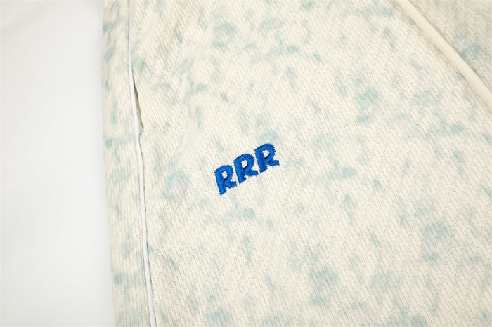 Close-up of blue RRR embroidery on acid wash sweatpants