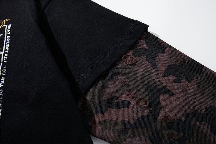 Close-up of the black short sleeve layered over a brown camouflage long sleeve with visible seam details