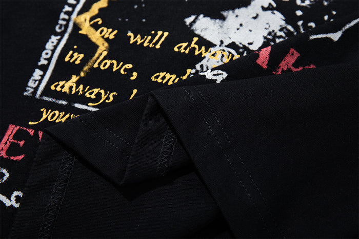 Close-up of the printed black T-shirt front showing graphic lettering and visible fabric folds