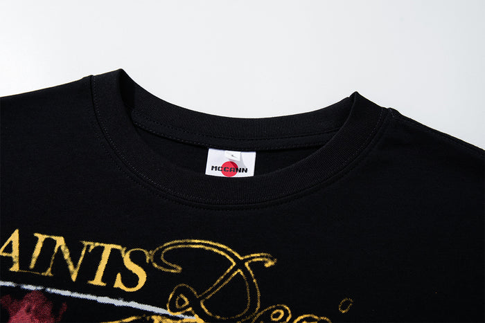 Close-up of the black crew neckline with ribbed trim, interior label, and partial gold graphic
