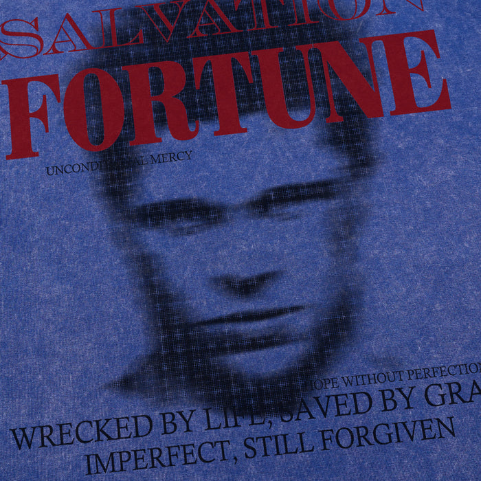 Close-up of Salvation Fortune graphic on blue acid wash T-shirt