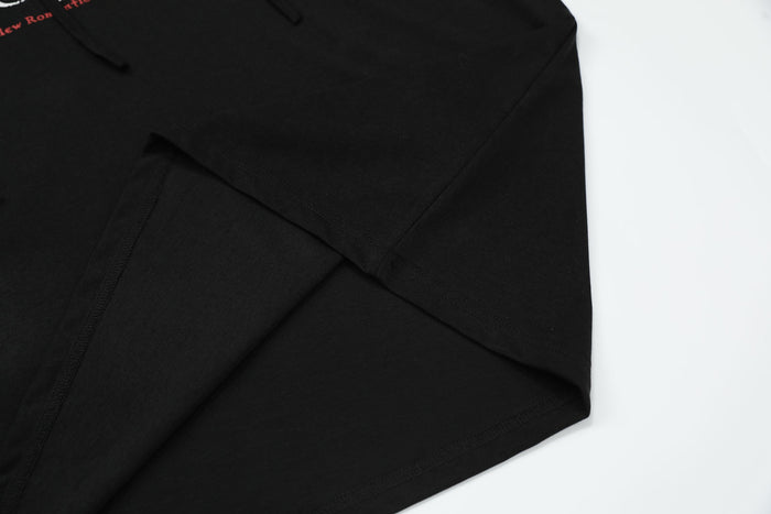 Black hoodie hem and sleeve crossover detail with visible seam stitching
