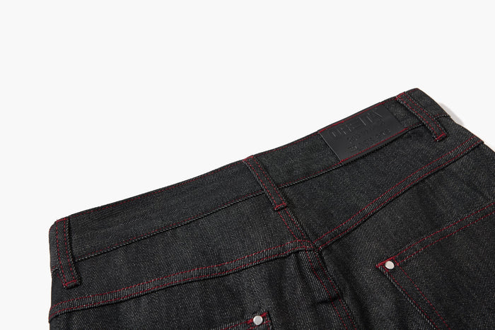 Close-up of back waistband with black brand patch and red contrast stitching