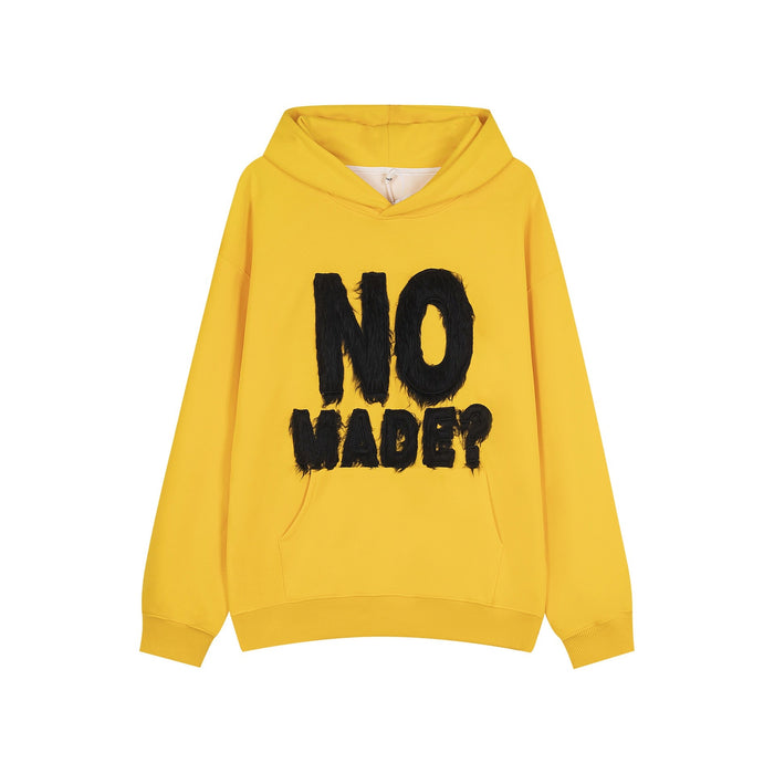 Yellow oversized hoodie with bold black furry raised NO MADE? lettering on the front chest