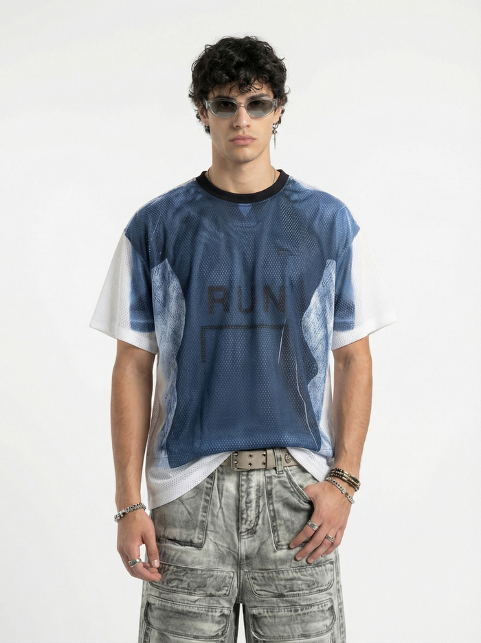 Model wearing a blue mesh graphic jersey with white sleeves, styled with cargo pants and sunglasses in a streetwear look