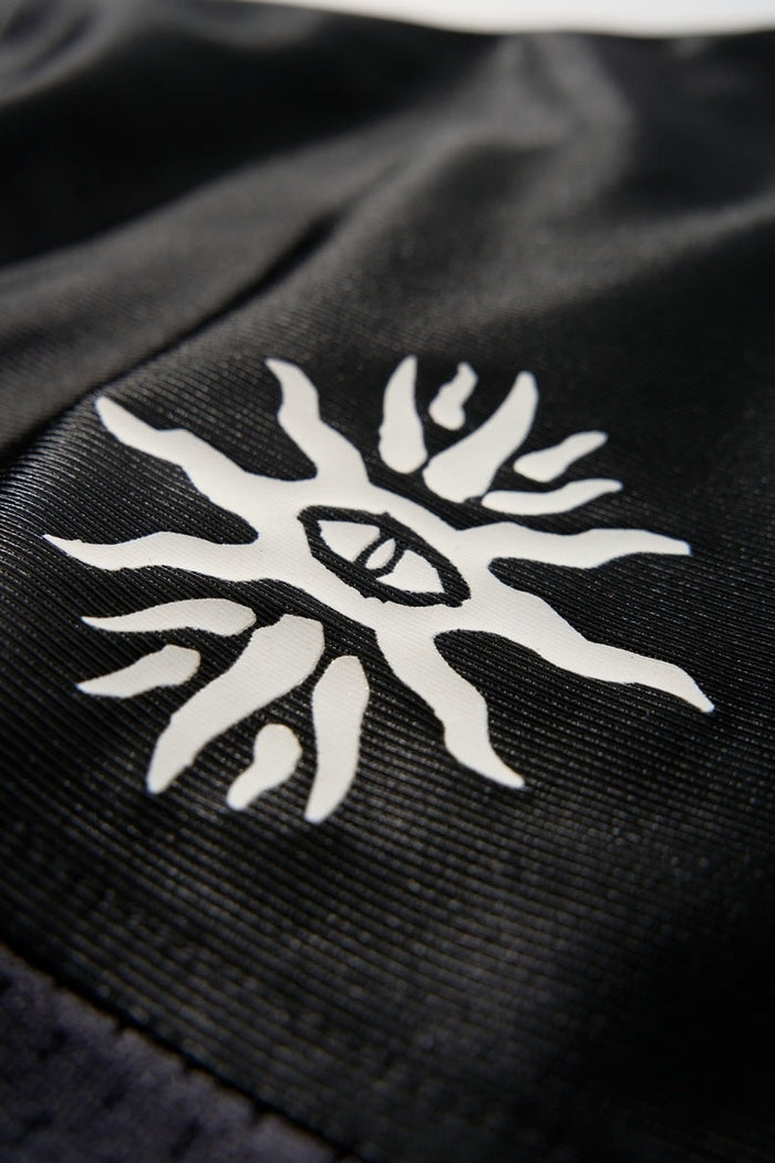 Close-up of black mesh football jersey with white Seakoff sun-eye graphic print on the chest