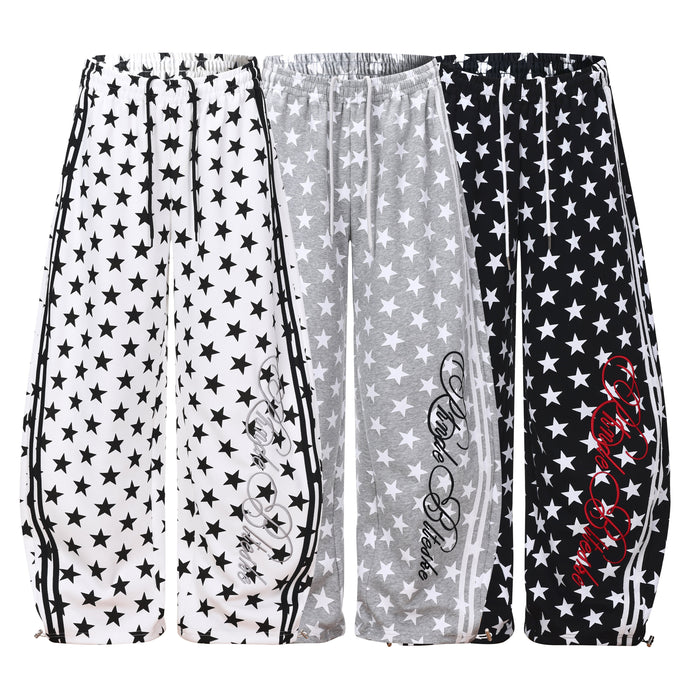 White wide-leg sweatpants with all-over black star print, side stripe panels, and script logo graphic on the leg