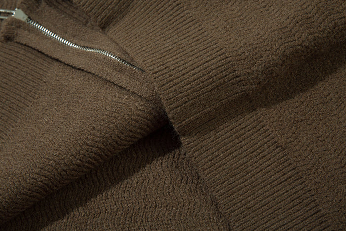 Close-up of brown knit hoodie fabric with visible zipper and ribbed texture