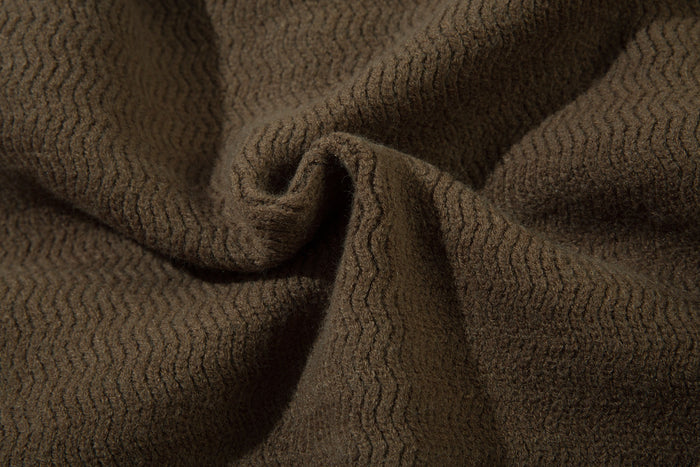Close-up of brown textured knit fabric showing soft wavy stitch pattern