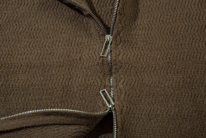 Close-up of the brown zip-up hoodie front with silver zipper pull and knit texture
