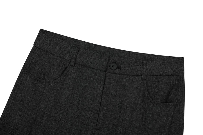 Close-up of black cargo pants waist with button closure, belt loops, and front pocket