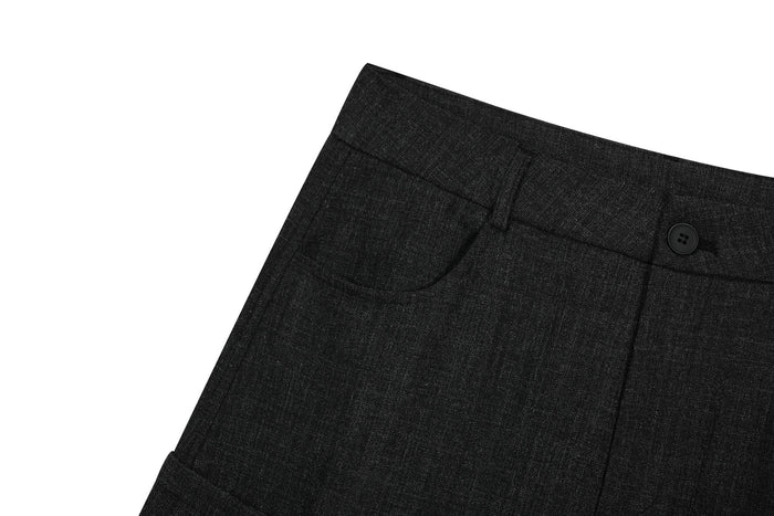 Close-up of black cargo pants front pocket, belt loop, and buttoned waistband