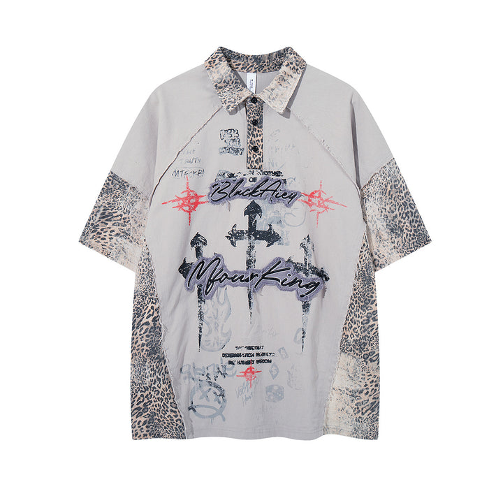 Front view of gray collared shirt with leopard-print collar and sleeve panels, graphic lettering and crosses