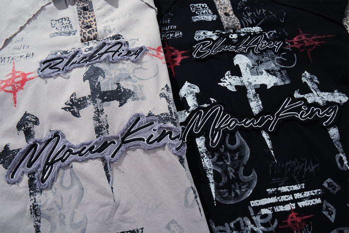 Close-up of gray and black shirt fronts showing layered graffiti lettering, crosses and red graphic accents