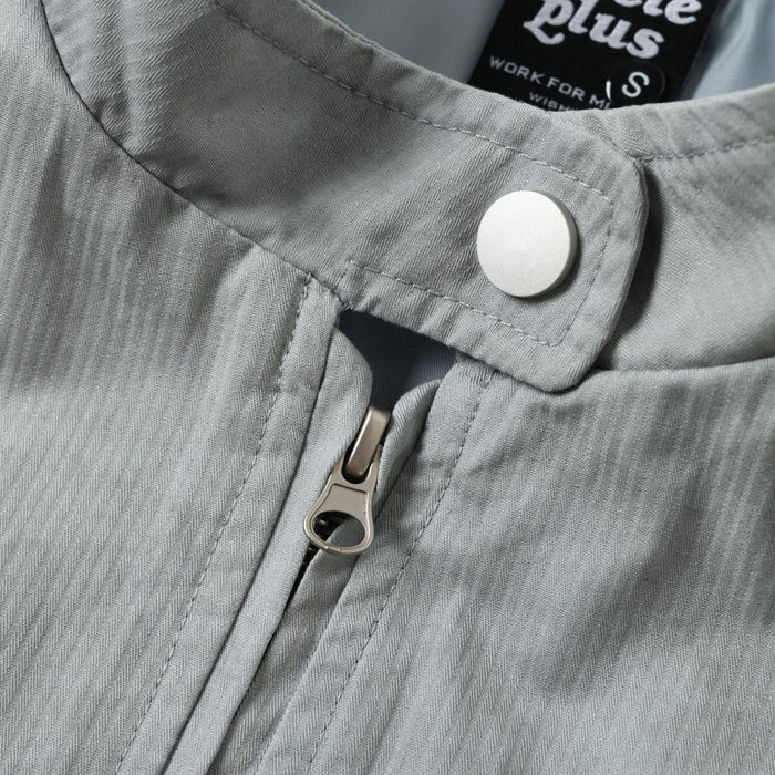 Close-up of the jacket collar and zipper with visible top button and seam stitching