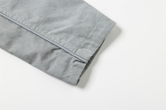 Close-up of light gray jacket sleeve cuff with straight hem stitching