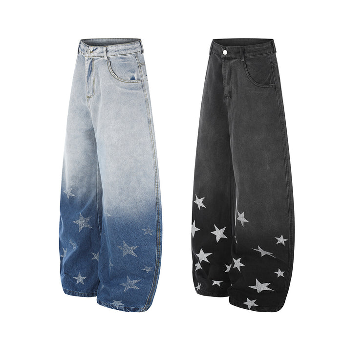 Angled view of light blue and black gradient wash wide-leg jeans with star prints near the hems